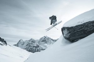 Skifahrer springt über Felsen